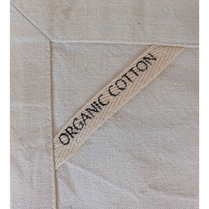 Detail of SeaNic Christmas napkin showing the organic cotton label and hand-stitched edging — highlighting the sustainable materials and quality craftsmanship.