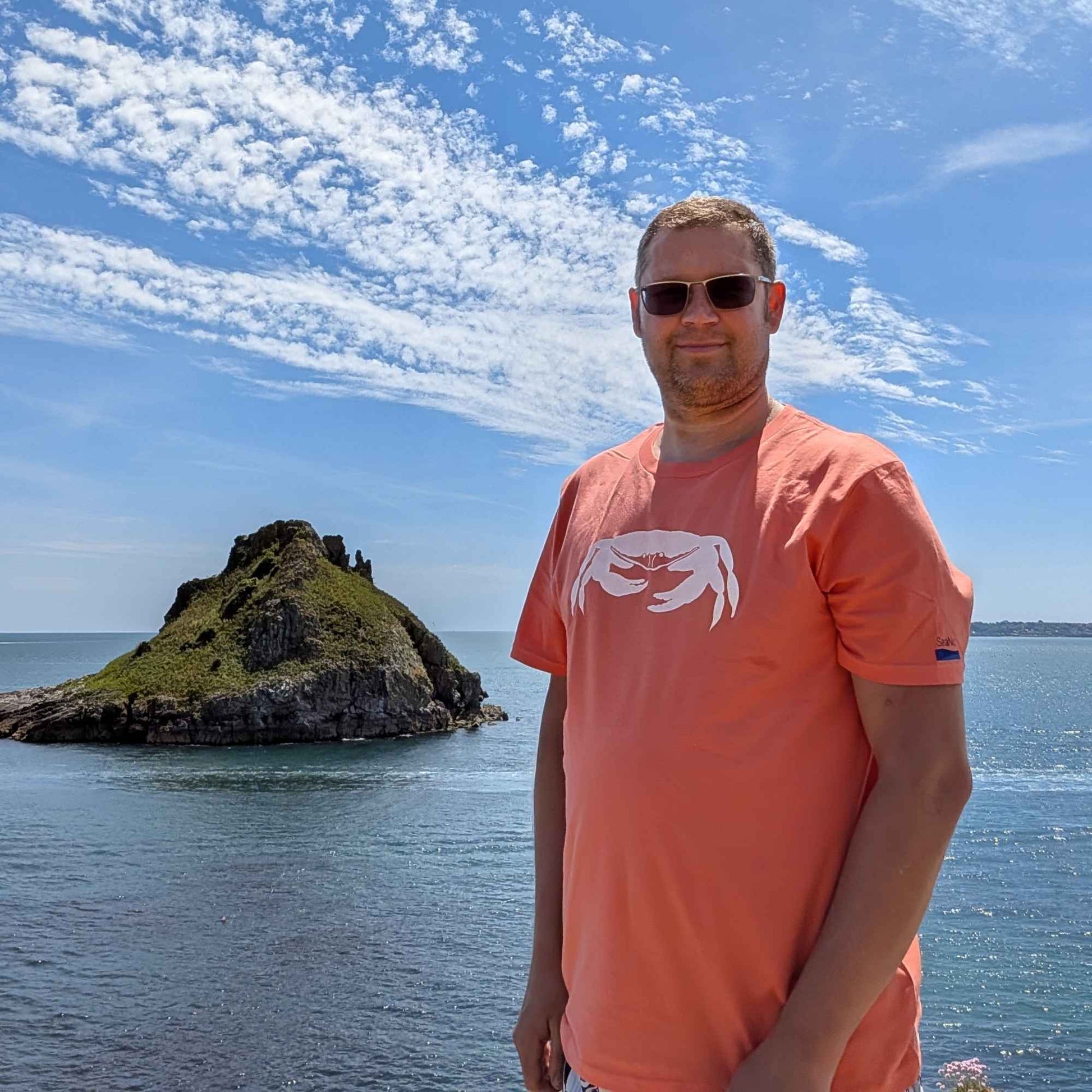 SeaNic crab t-shirt in coral, worn on the Devonshire coast