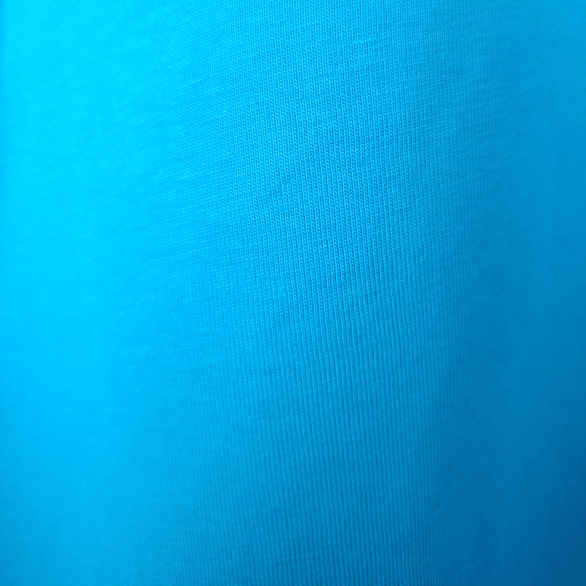 Close-up of bright blue GOTS organic cotton fabric texture showing high-quality knit for SeaNic sustainable t-shirts.
