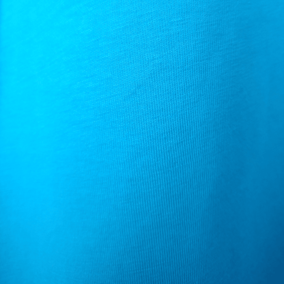 Close-up of bright blue GOTS organic cotton fabric texture showing high-quality knit for SeaNic sustainable t-shirts.