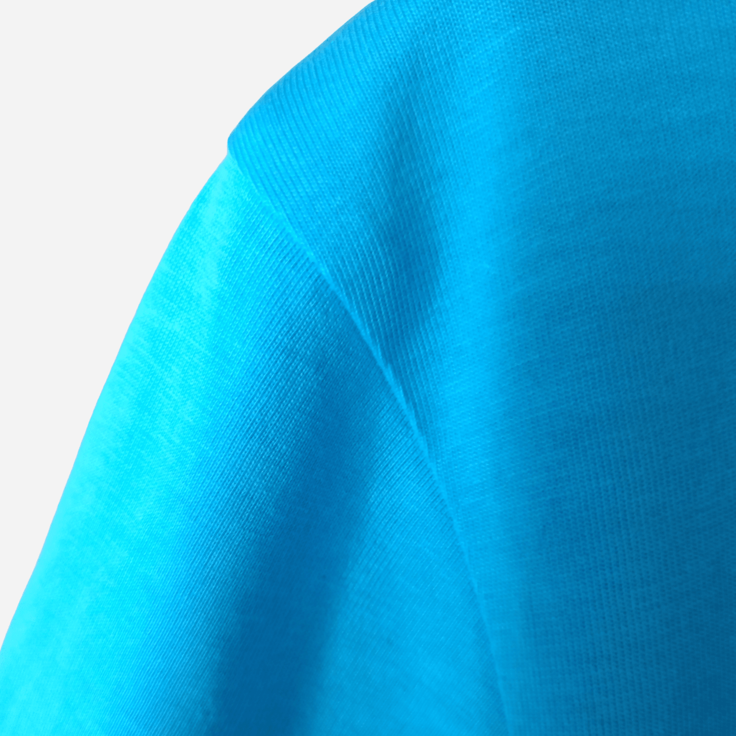 Reinforced shoulder seam stitching on an aqua organic cotton t-shirt, handcrafted by SeaNic for long-lasting coastal wear.