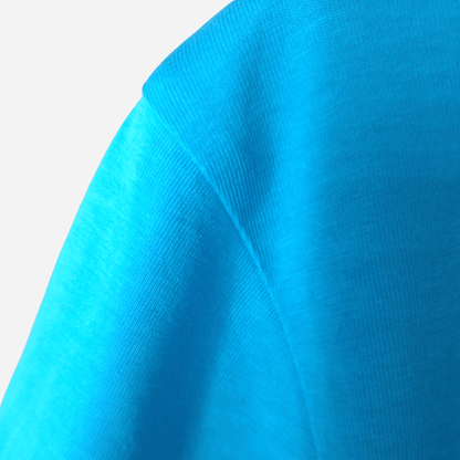 Reinforced shoulder seam stitching on an aqua organic cotton t-shirt, handcrafted by SeaNic for long-lasting coastal wear.